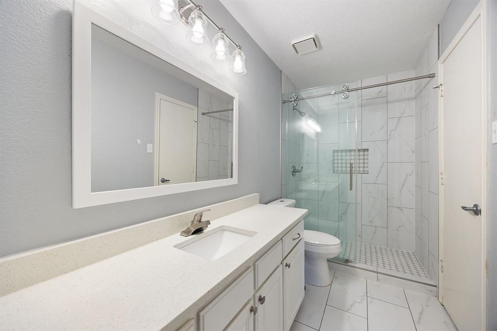 2016 Falcon Ridge Drive, Unit B Carrollton, TX 75010 - Photo 7 of 11 Bathroom featuring a marble finish shower, vanity, and light marble finish flooring