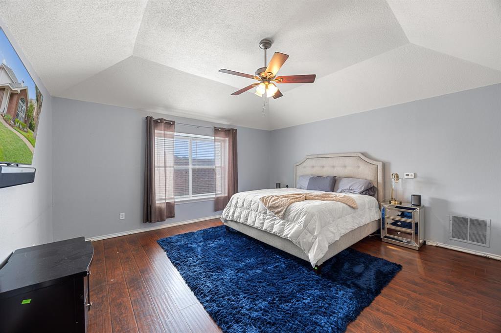 2016 Falcon Ridge Drive, Unit B Carrollton, TX 75010 - Photo 9 of 11 Bedroom featuring dark wood finished floors, a textured ceiling, a ceiling fan, and lofted ceiling