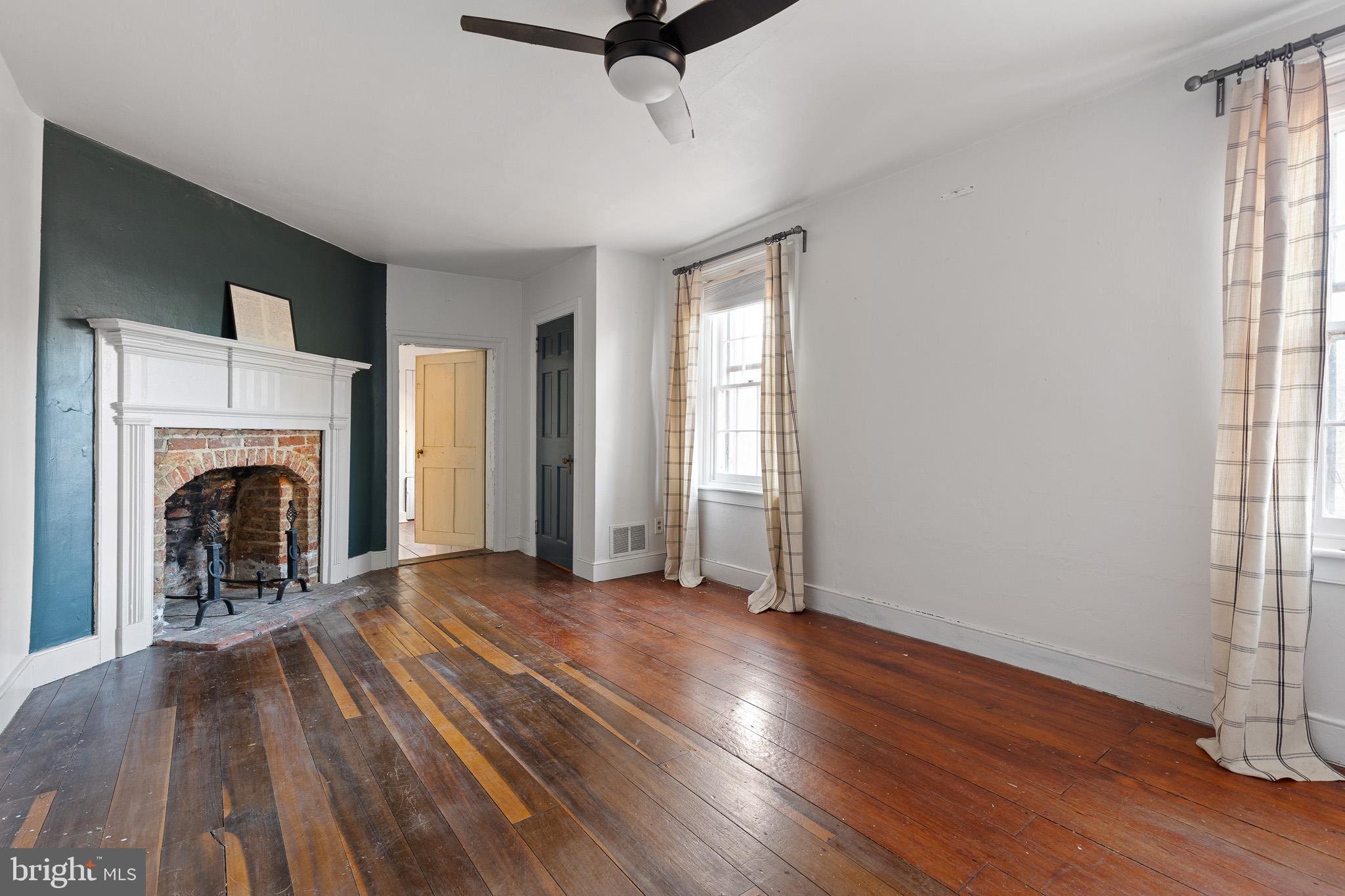 547 Concord Road Glen Mills, PA 19342 - Photo 17 of 42 an empty room with wooden floor a fireplace and windows