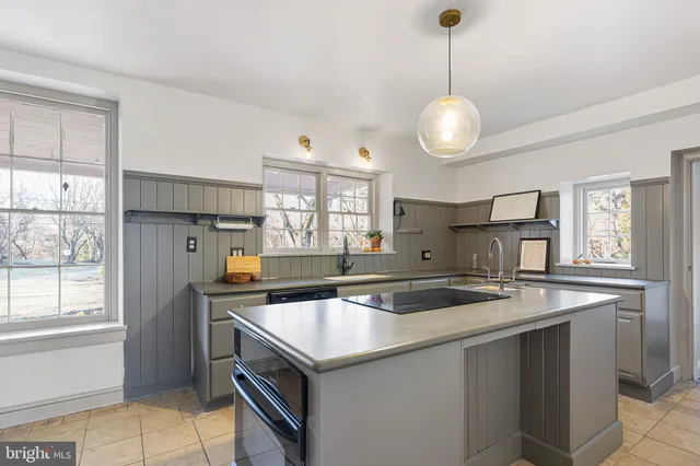a kitchen that has a sink a window and stainless steel appliances