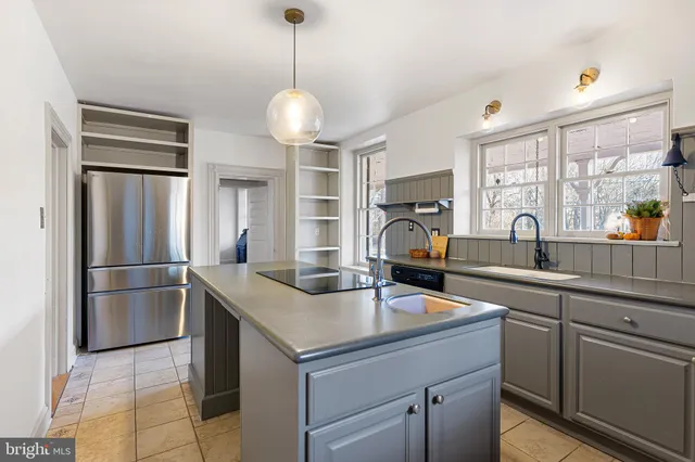 a kitchen with stainless steel appliances a sink a counter appliances and cabinets