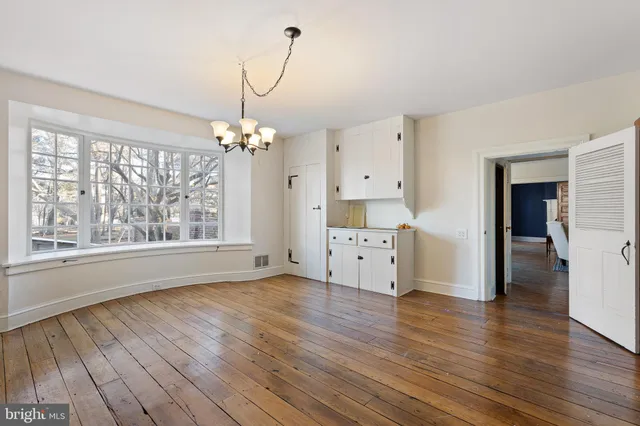 a view of a room with wooden floor and windows