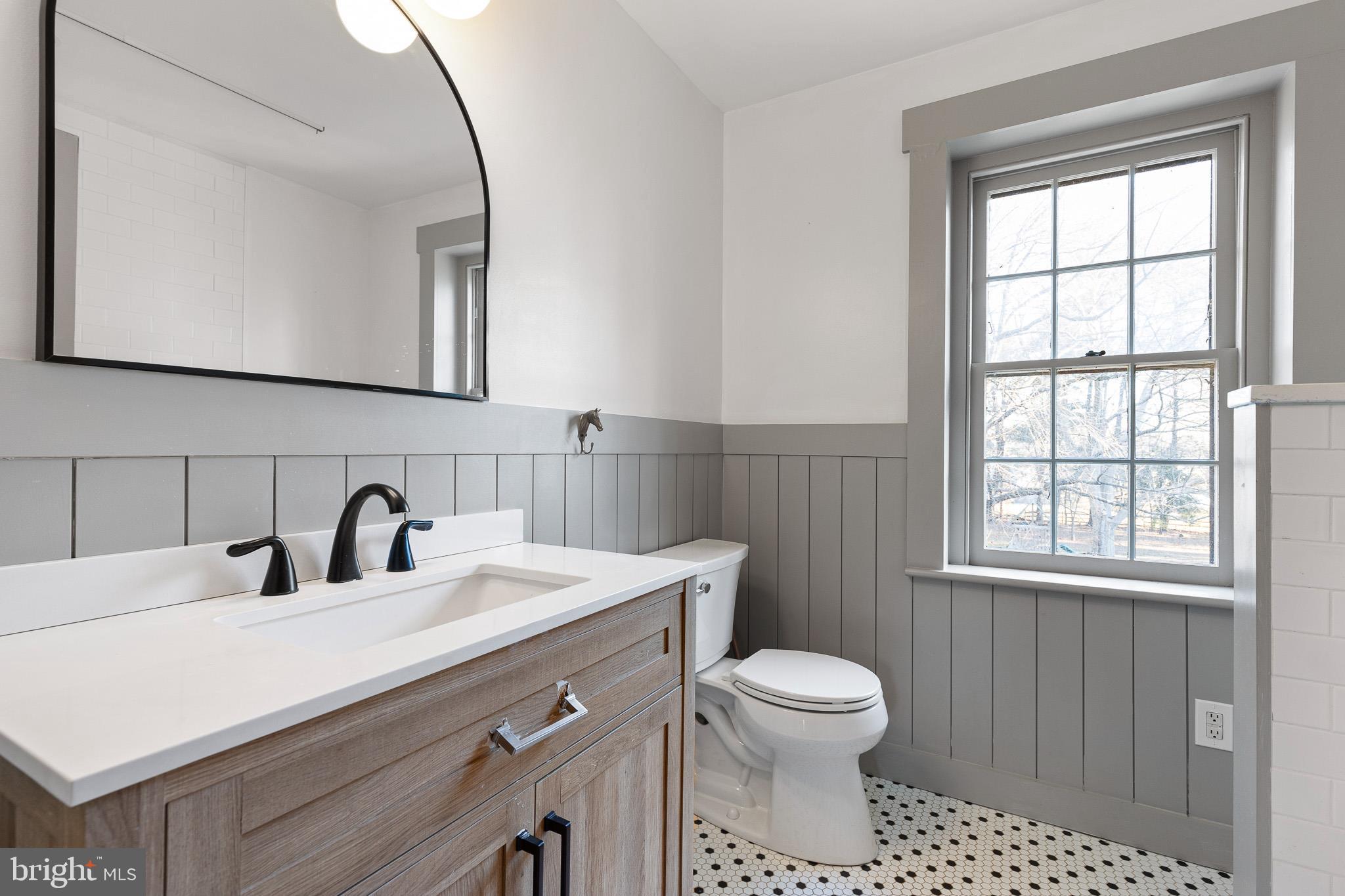 547 Concord Road Glen Mills, PA 19342 - Photo 10 of 42 a bathroom with a toilet a sink a mirror and a window