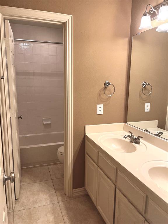4101 White Porch Road Plano, TX 75024 - Photo 16 of 18 Hallway bathroom with dual sink vanity, white cabinetry and chrome fixtures.