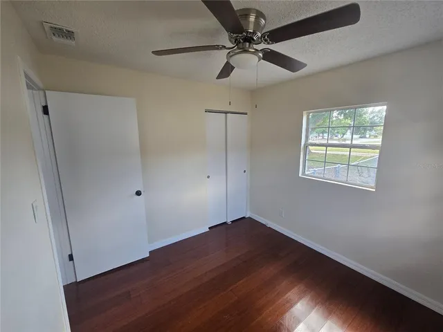 a view of a big room with wooden floor and windows