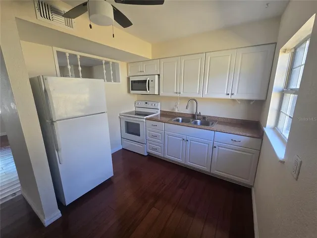 a kitchen with stainless steel appliances granite countertop a refrigerator a sink a stove a microwave and cabinets