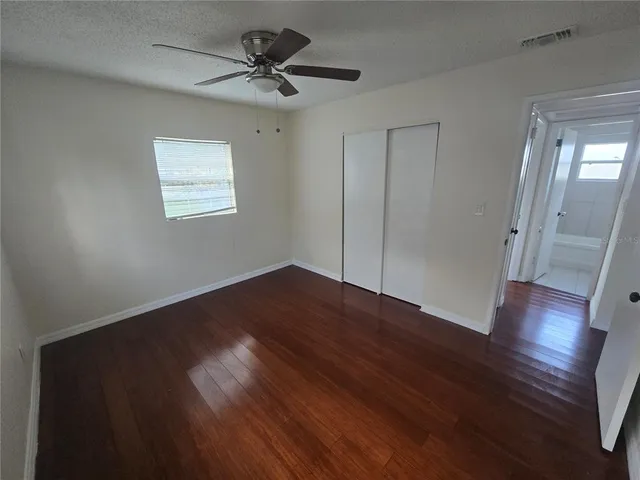 a view of empty room with wooden floor