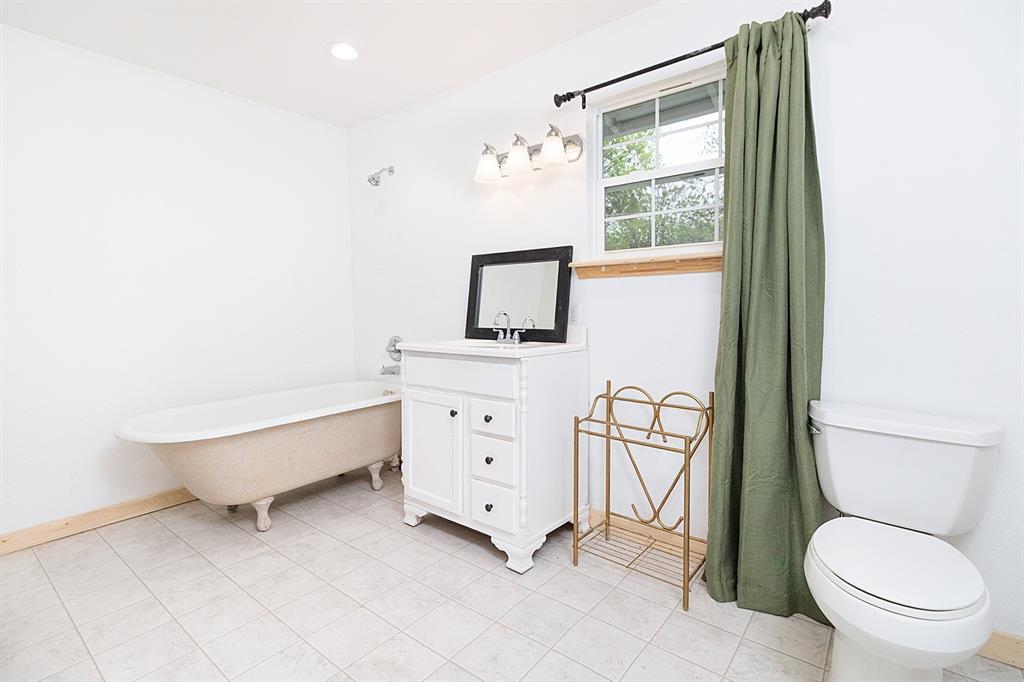 607 West 6th Street Brady, TX 76825 - Photo 17 of 32 a spacious bathroom with a toilet sink and mirror