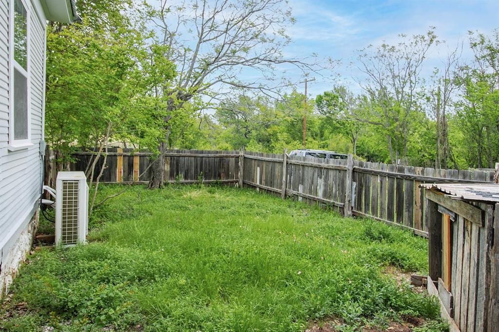 607 West 6th Street Brady, TX 76825 - Photo 30 of 32 a view of backyard with wooden fence and large trees