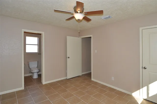 a view of a room with a ceiling fan and a bathroom