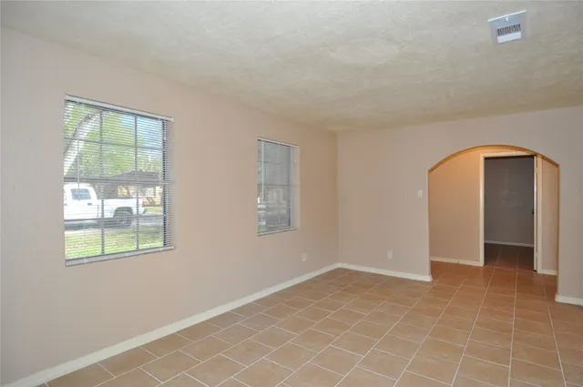 a view of an empty room with window and closet area