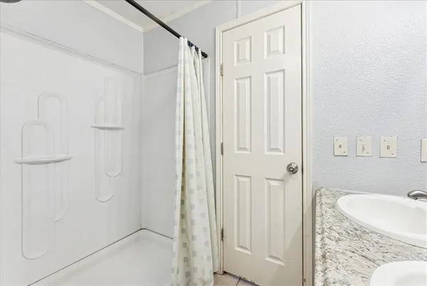 a bathroom with a granite countertop shower and a sink