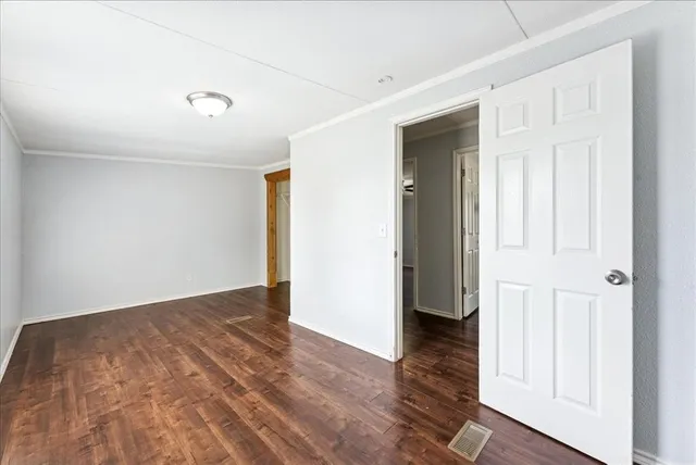 an empty room with wooden floor and closet