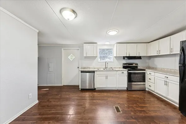 a kitchen with granite countertop white cabinets and white appliances