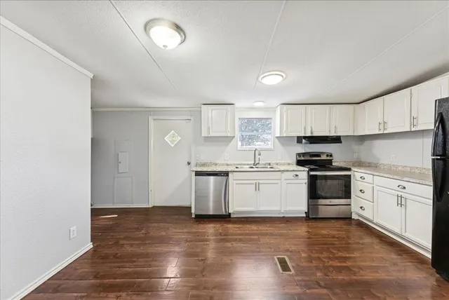 a kitchen with granite countertop white cabinets and white appliances