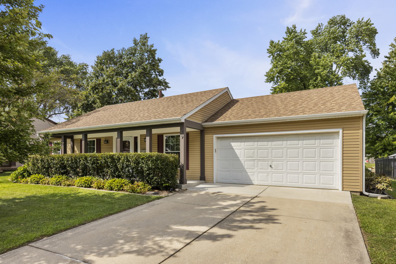 a front view of a house with a garden and trees