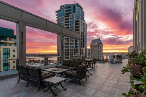 a roof deck with outdoor seating and city view