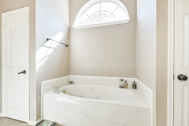 a bedroom with a large bed and chandelier