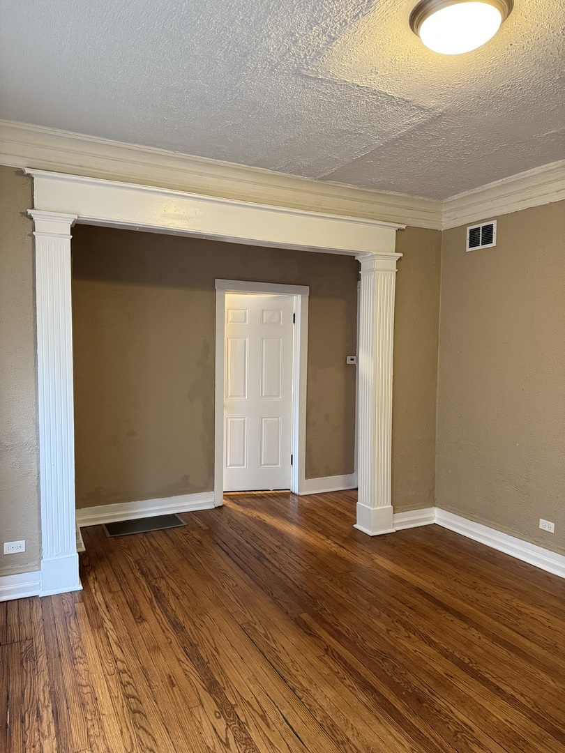 5658 South Honore Street, Unit 1F Chicago, IL 60636 - Photo 3 of 7 a view of an empty room with wooden floor and a window
