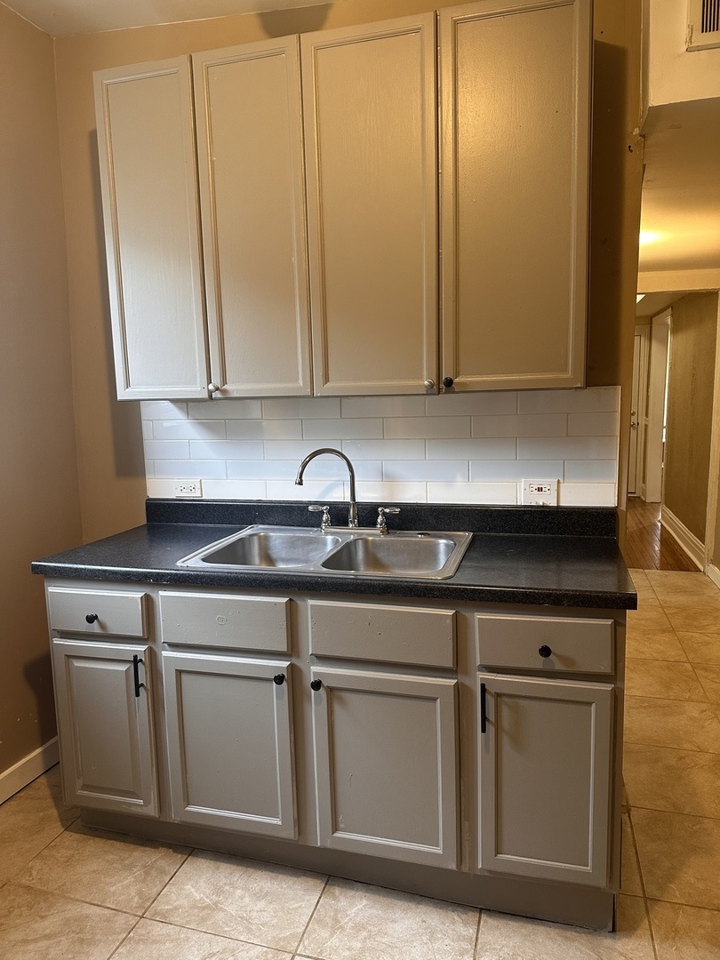 5658 South Honore Street, Unit 1F Chicago, IL 60636 - Photo 4 of 7 a kitchen with stainless steel appliances granite countertop a sink a stove and a microwave