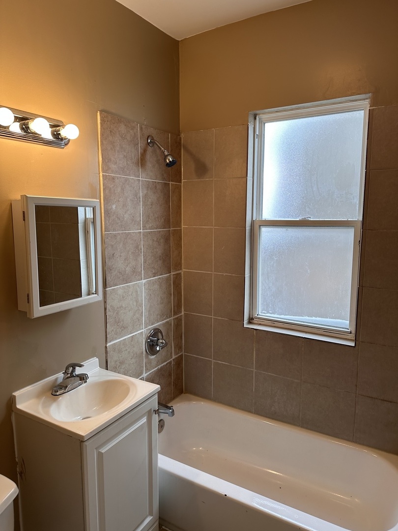 5658 South Honore Street, Unit 1F Chicago, IL 60636 - Photo 6 of 7 a bathroom with a sink mirror toilet and bathtub