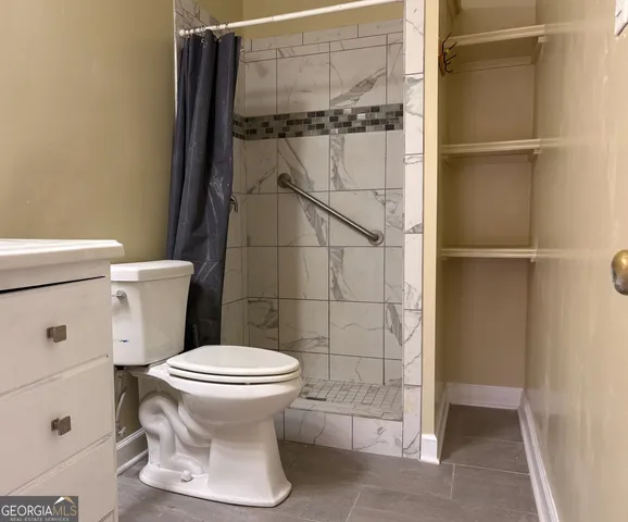 a bathroom with a toilet and a shower