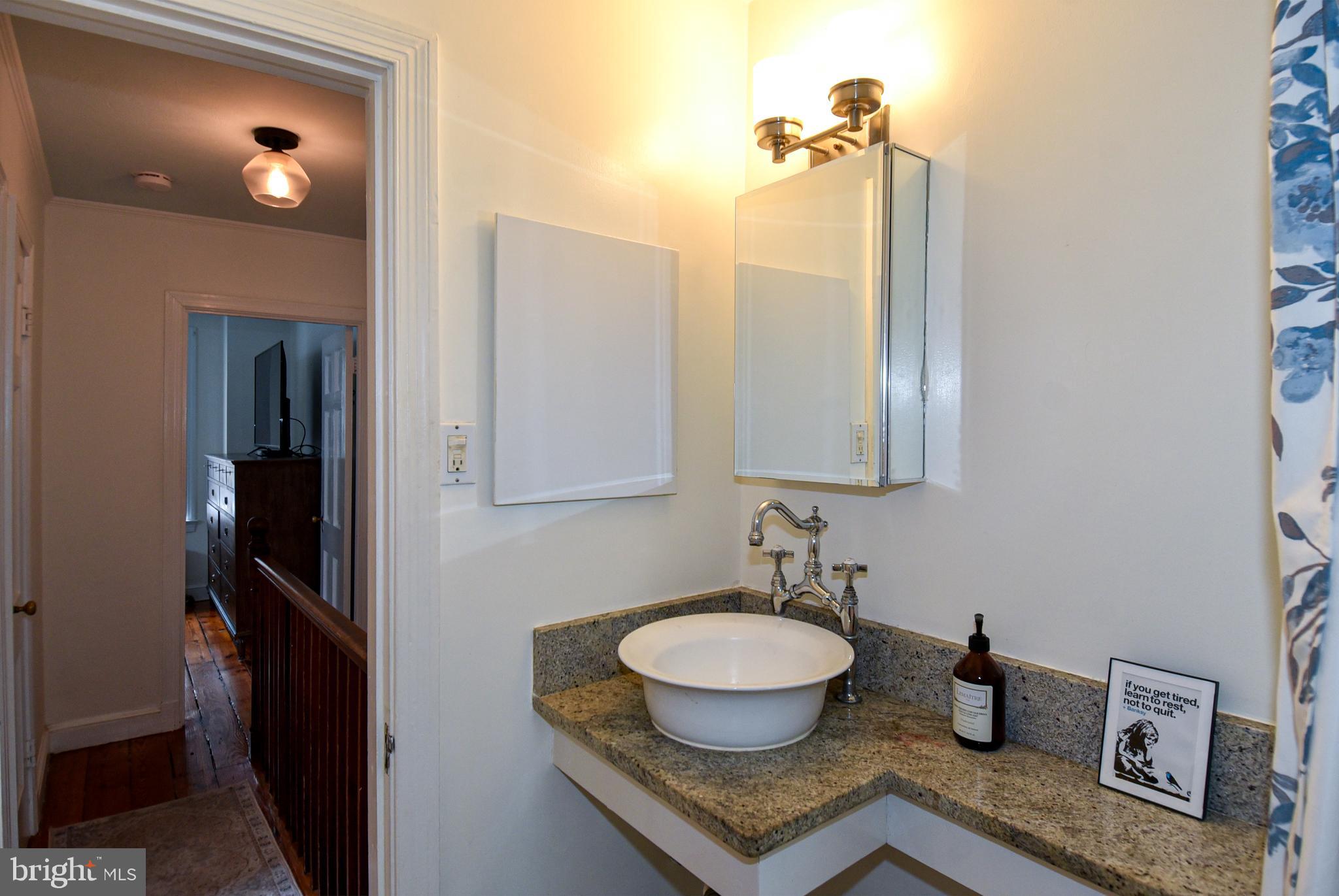 1412 27th Street Northwest Washington, DC 20007 - Photo 22 of 28 a bathroom with a granite countertop sink and a mirror