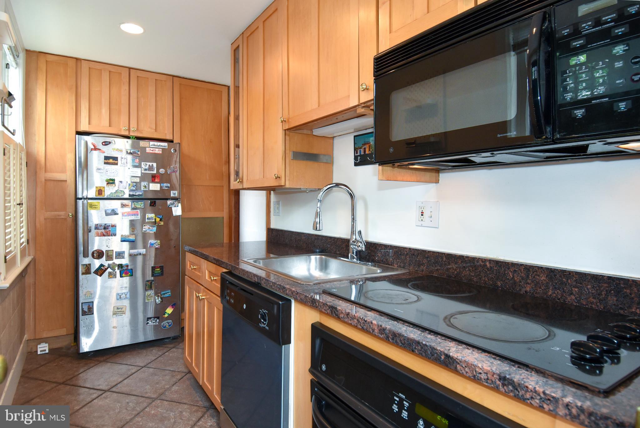1412 27th Street Northwest Washington, DC 20007 - Photo 4 of 28 a kitchen with stainless steel appliances granite countertop a sink stove and microwave