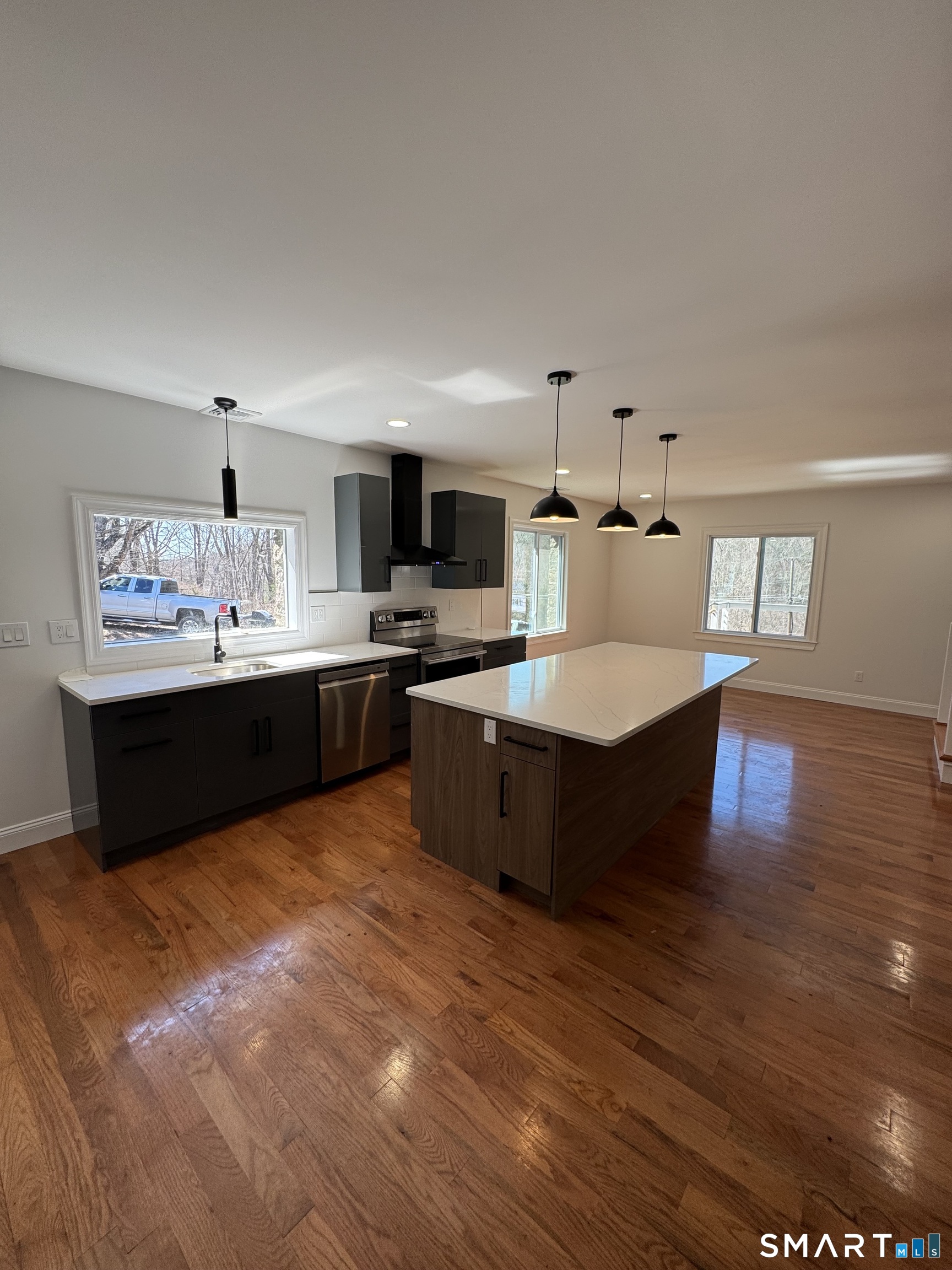 243 Long Hill Road Andover, CT 06232 - Photo 11 of 31 a living room with stainless steel appliances kitchen island granite countertop a sink dishwasher a refrigerator and a oven with wooden floor
