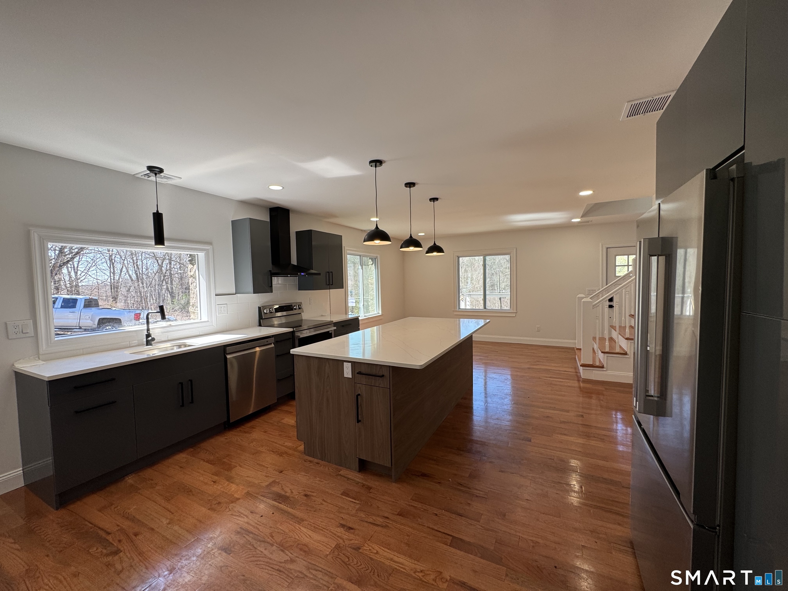 243 Long Hill Road Andover, CT 06232 - Photo 10 of 31 a large kitchen with kitchen island a sink dishwasher a refrigerator and a stove with wooden floor