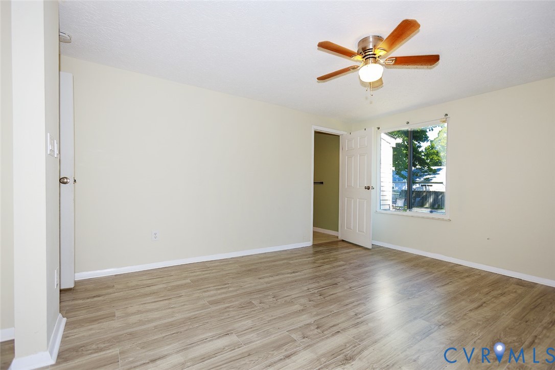 925 Fluvanna Road Newport News, VA 23601 - Photo 11 of 25 an empty room with wooden floor chandelier fan and windows