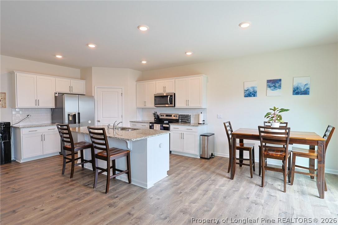 2129 Clydesmill Road Fayetteville, NC 28314 - Photo 8 of 36 a kitchen with a dining table chairs and refrigerator