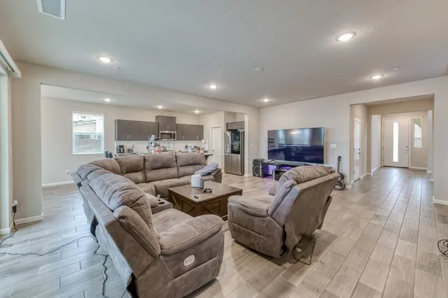 a living room with furniture and a wooden floor