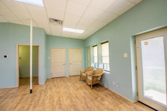 an empty room with wooden floor and mirror