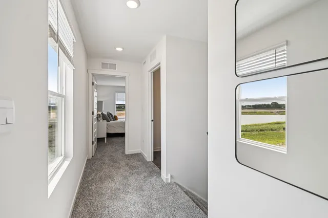 a view of a hallway with a livingroom and a bathroom