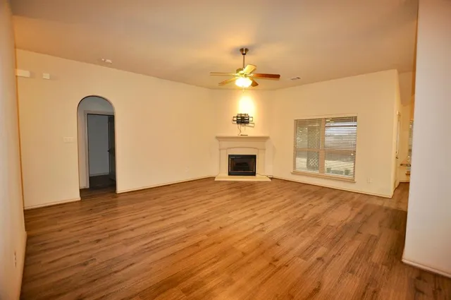 a view of empty room with wooden floor and fireplace