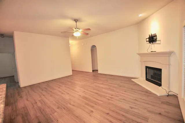 a view of empty room with wooden floor and fireplace