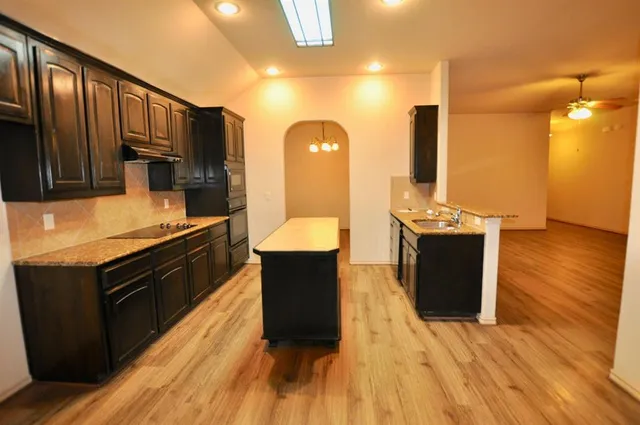 a kitchen with stainless steel appliances wooden floors and wooden cabinets