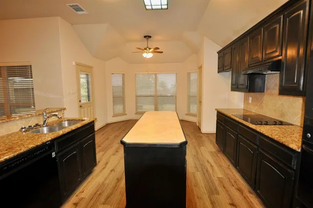 a kitchen with granite countertop stainless steel appliances and wooden cabinets