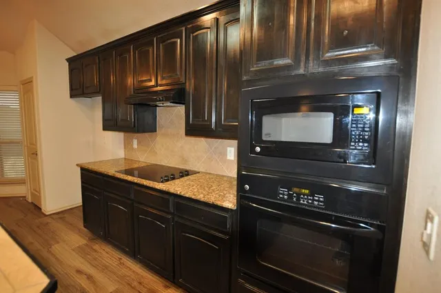 a kitchen with granite countertop stainless steel appliances and wooden cabinets
