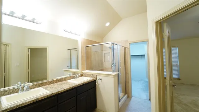 a bathroom with a granite countertop sink a mirror and a shower