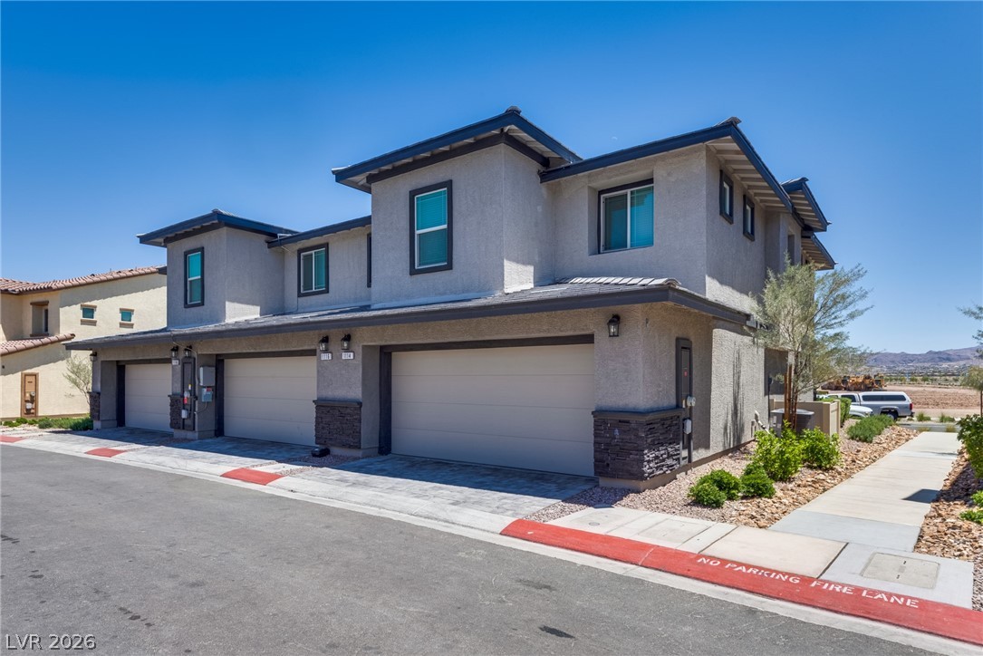 1114 Scarlet Sparrow Street Henderson, NV 89011 - Photo 3 of 25 Clean lines and modern design define this multi-unit dwelling, complete with individual garages and neat landscaping.