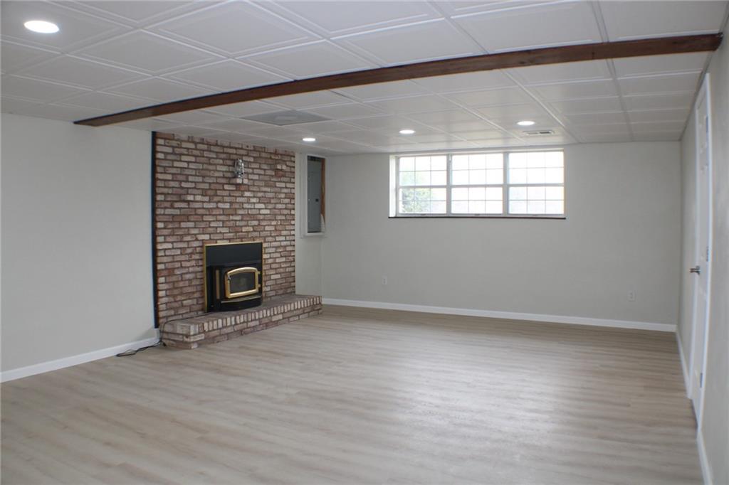 626 Ekastown Road Sarver, PA 16055 - Photo 10 of 50 an empty room with wooden floor and fireplace