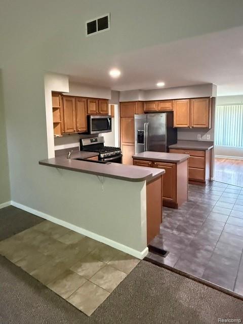 465 Trombley Road Troy, MI 48083 - Photo 5 of 24 Kitchen featuring wood-finish cabinetry, stainless steel appliances, a center island, and a breakfast bar