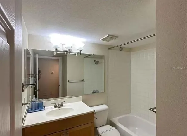 a bathroom with a sink vanity mirror and toilet