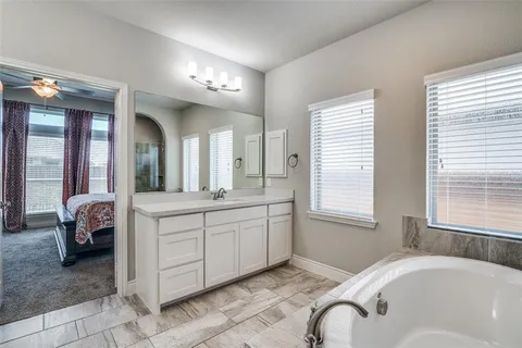 a spacious bathroom with a granite countertop tub sink and mirror