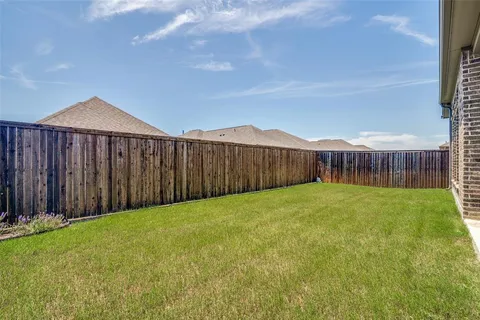 a view of a backyard with wooden fence