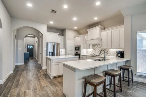 a kitchen with appliances a sink and cabinets