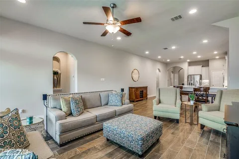 a living room with furniture kitchen view and a chandelier