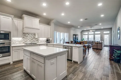 a kitchen with a sink stove cabinets and refrigerator